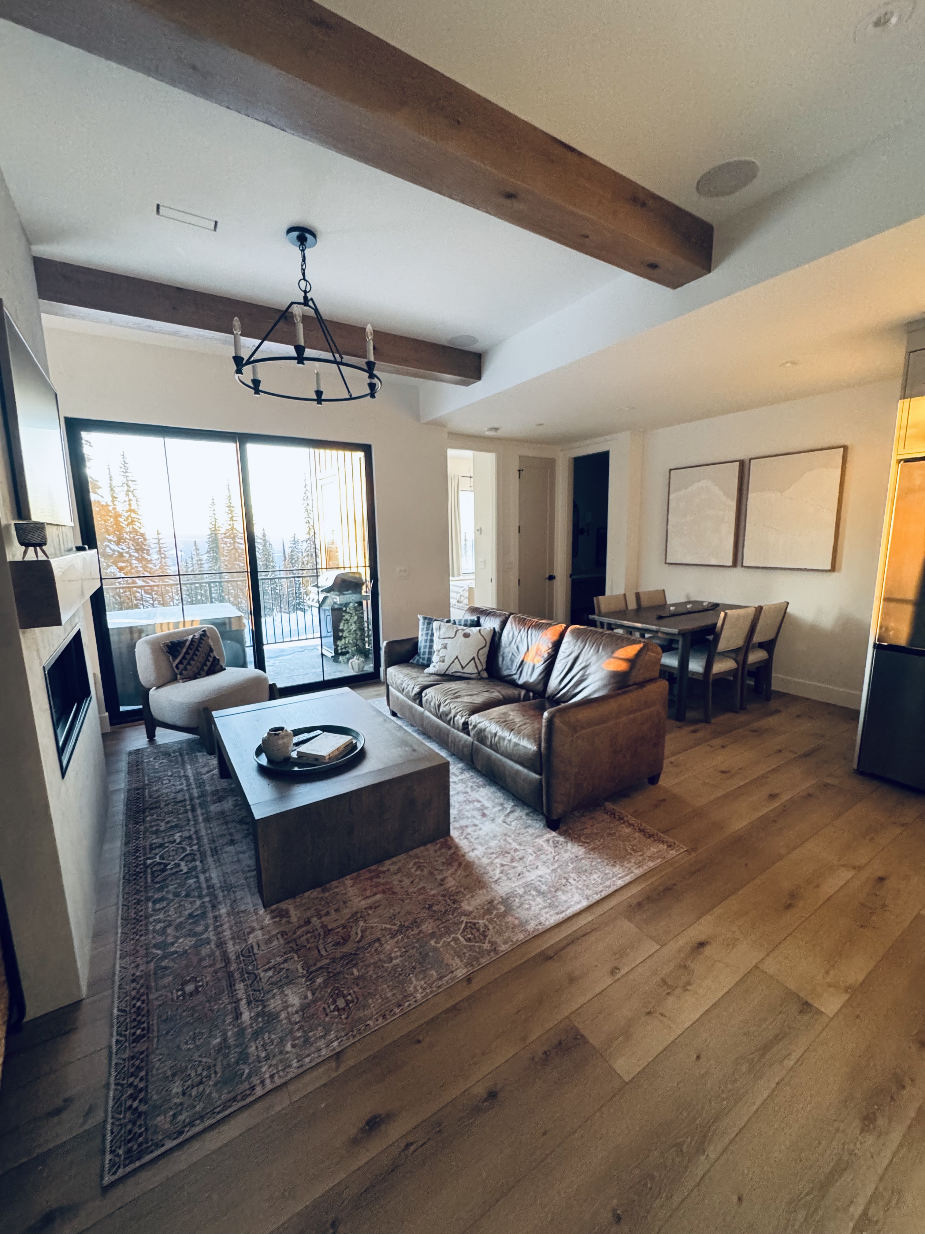 Open living and dining area with leather sofa and mountain view